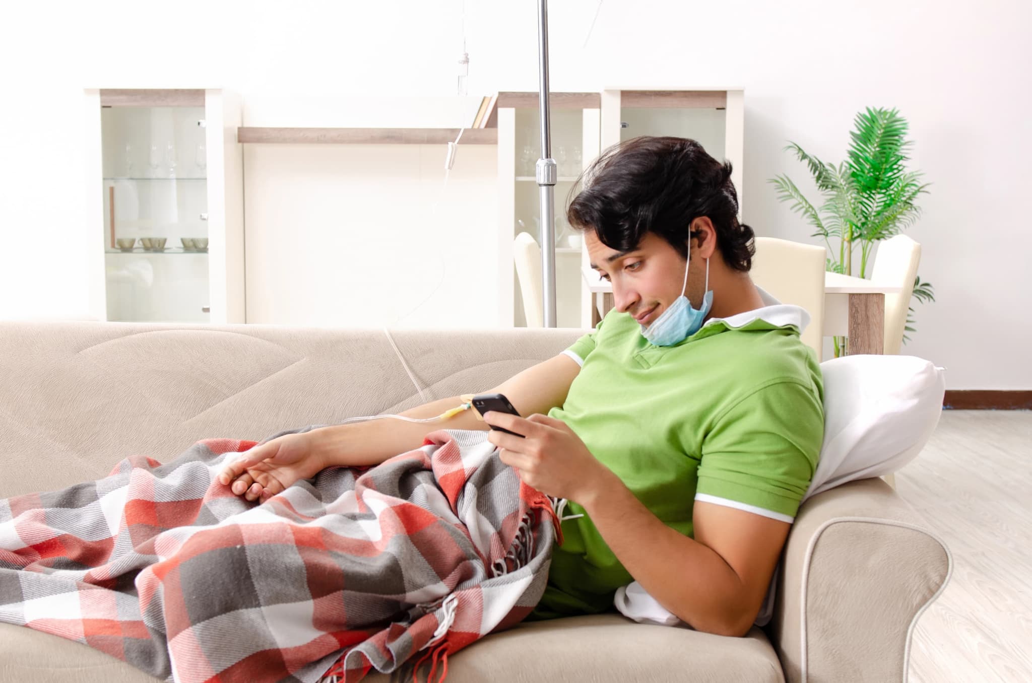 Man laying on couch getting mobile IV drip.